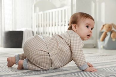 Photo of Cute baby crawling on floor at home