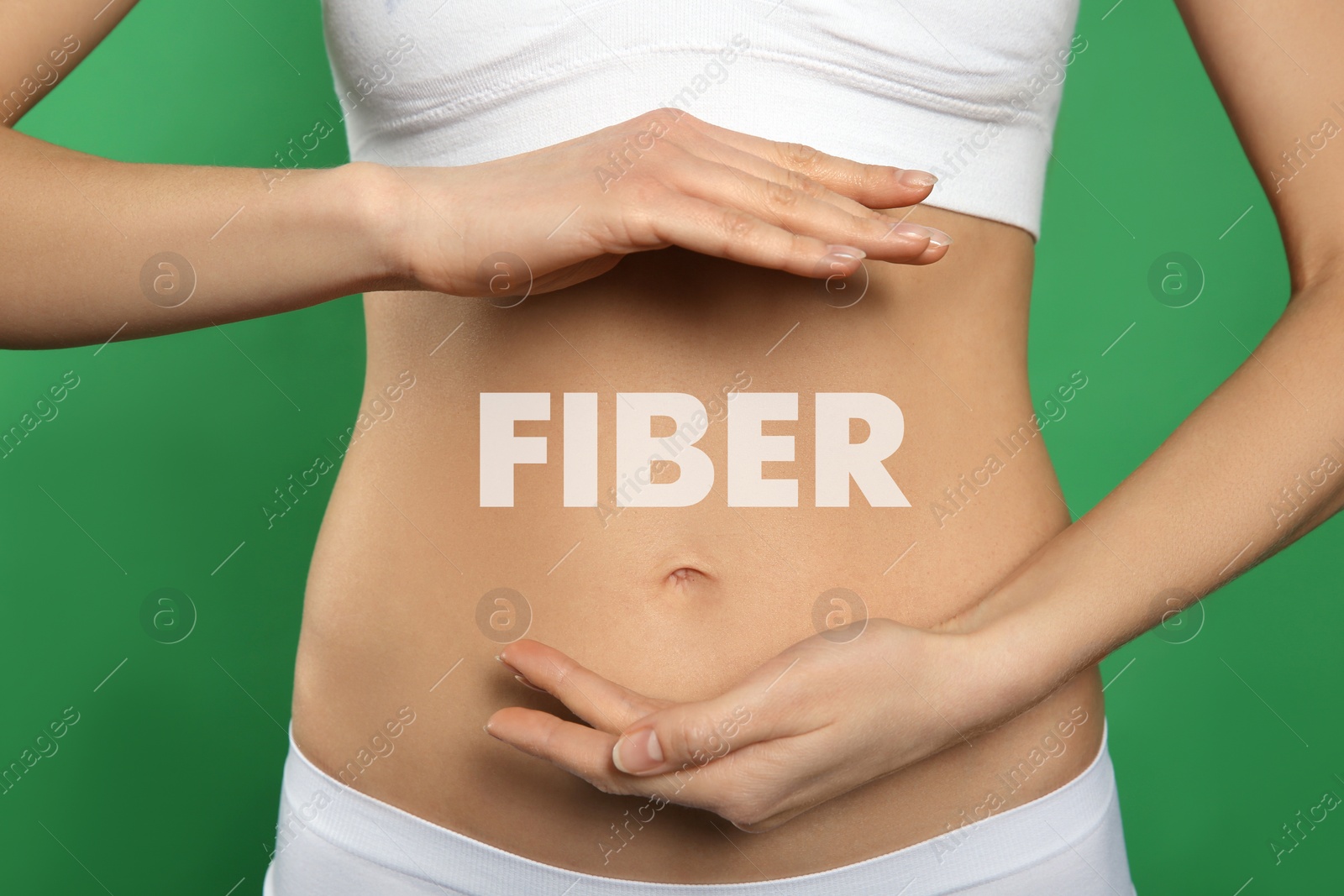 Image of Woman holding hands near belly and word Fiber, closeup