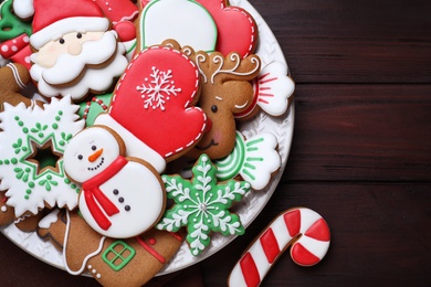 Photo of Delicious gingerbread Christmas cookies on wooden table, flat lay