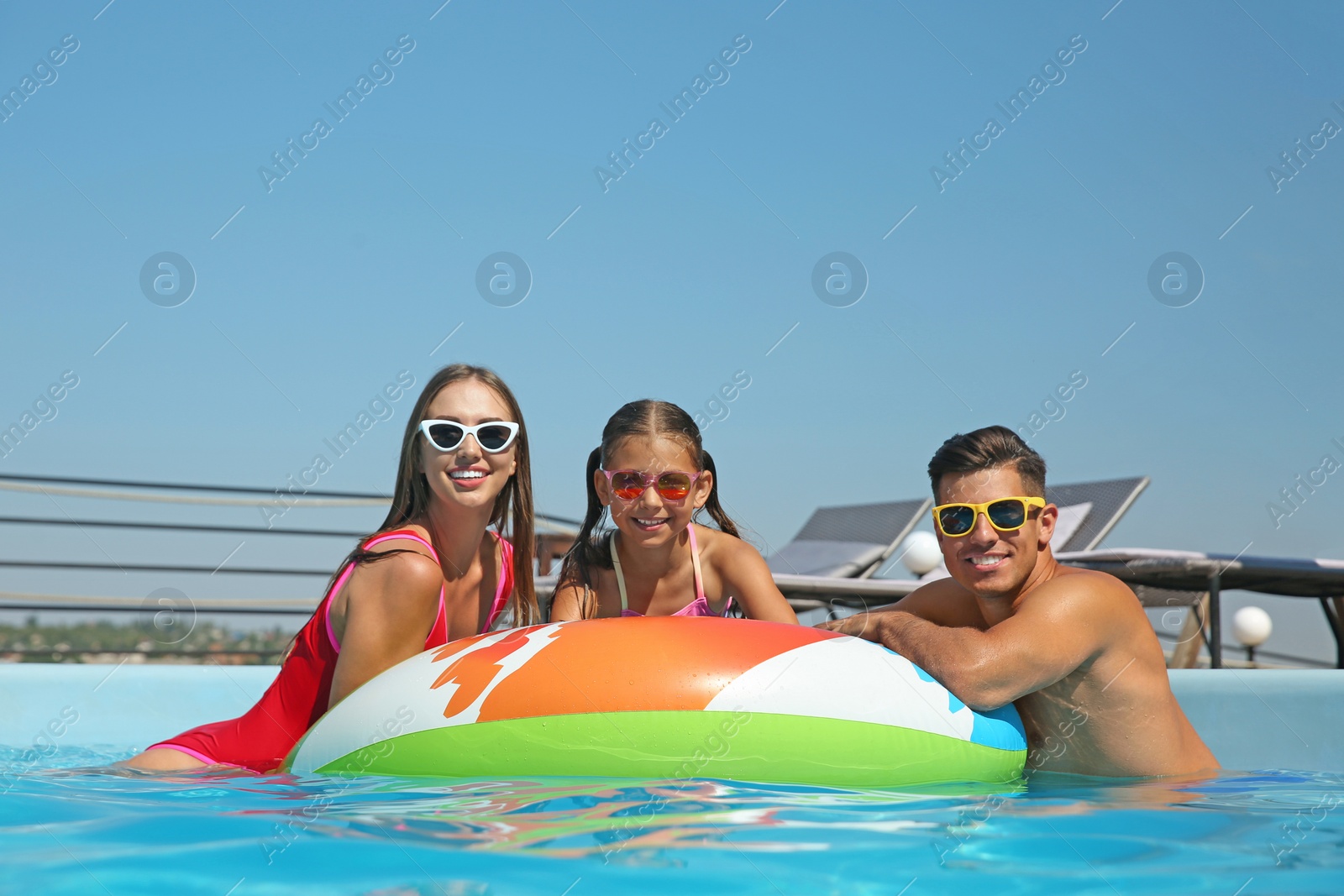 Photo of Happy family on inflatable ring in swimming pool