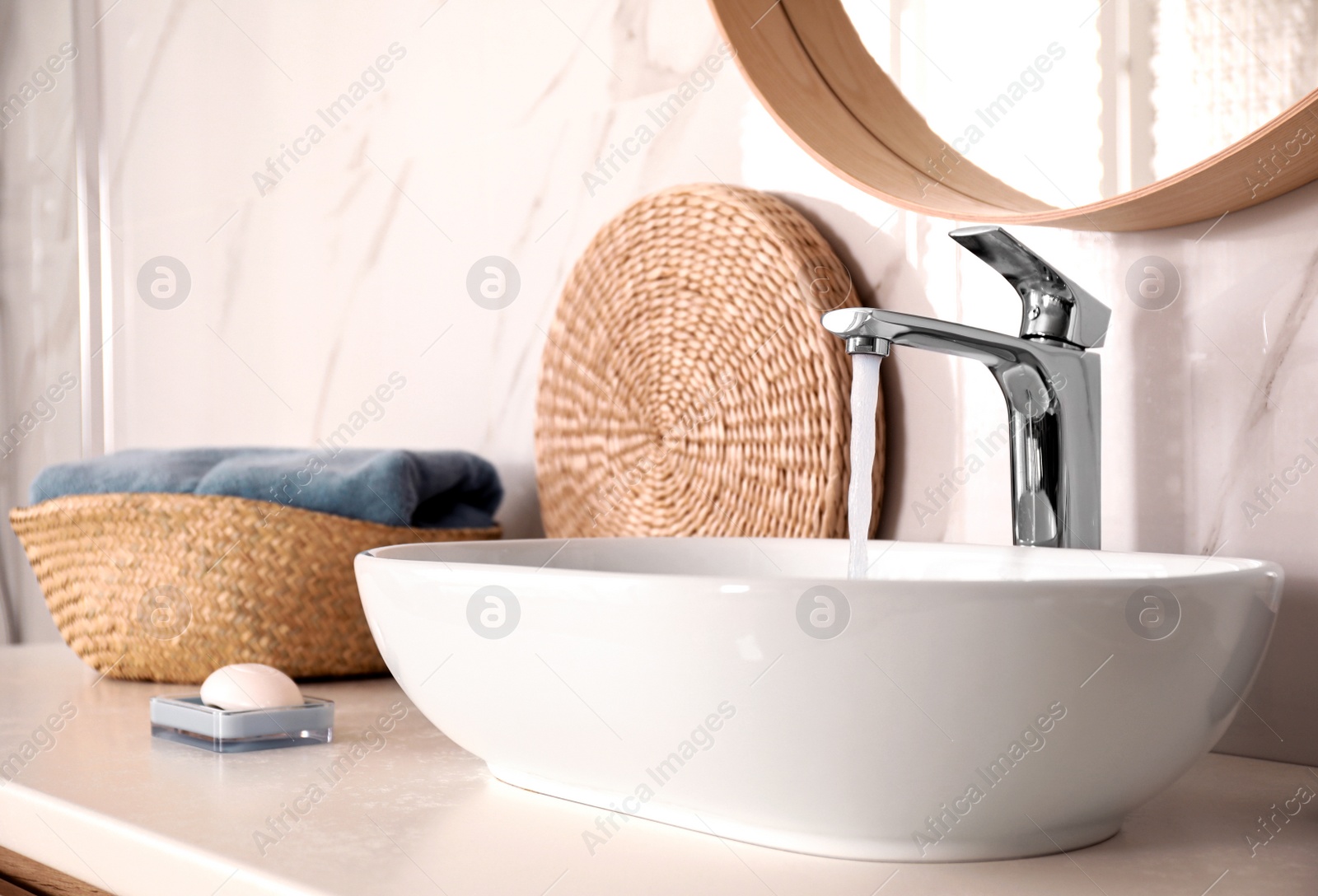 Photo of Sink with running water in stylish bathroom interior