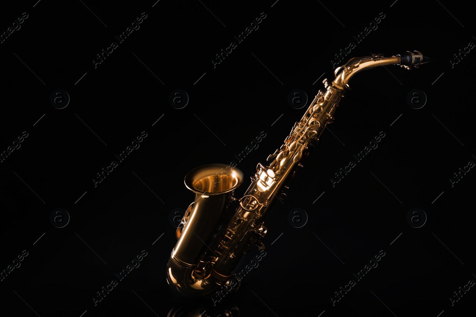 Photo of Beautiful saxophone on black background. Musical instrument