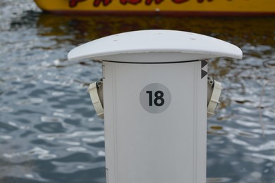 Photo of Charging station for boats with electrical outlets in harbor near sea