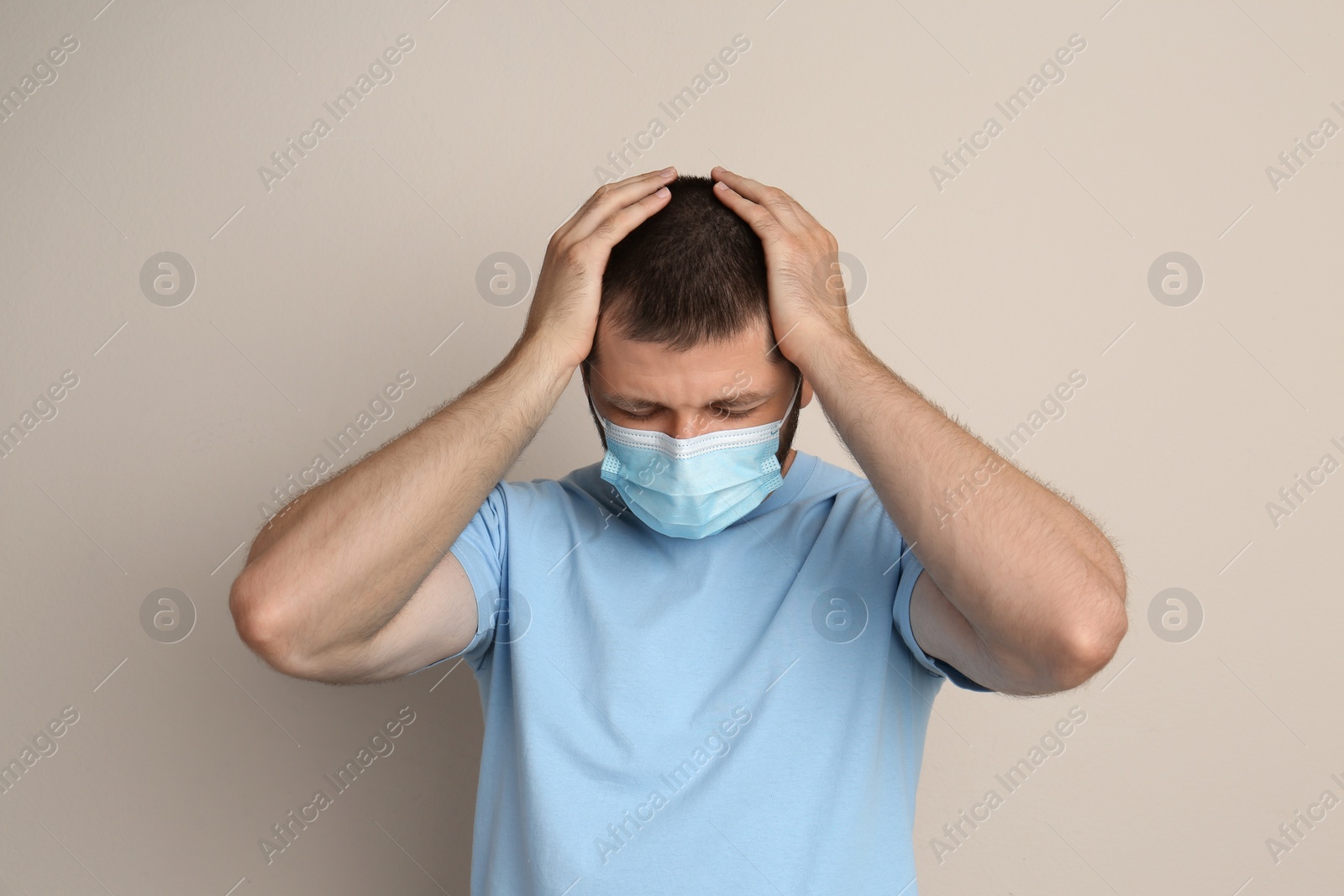 Photo of Stressed man in protective mask on beige background. Mental health problems during COVID-19 pandemic