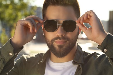 Photo of Handsome man in sunglasses outdoors on sunny day