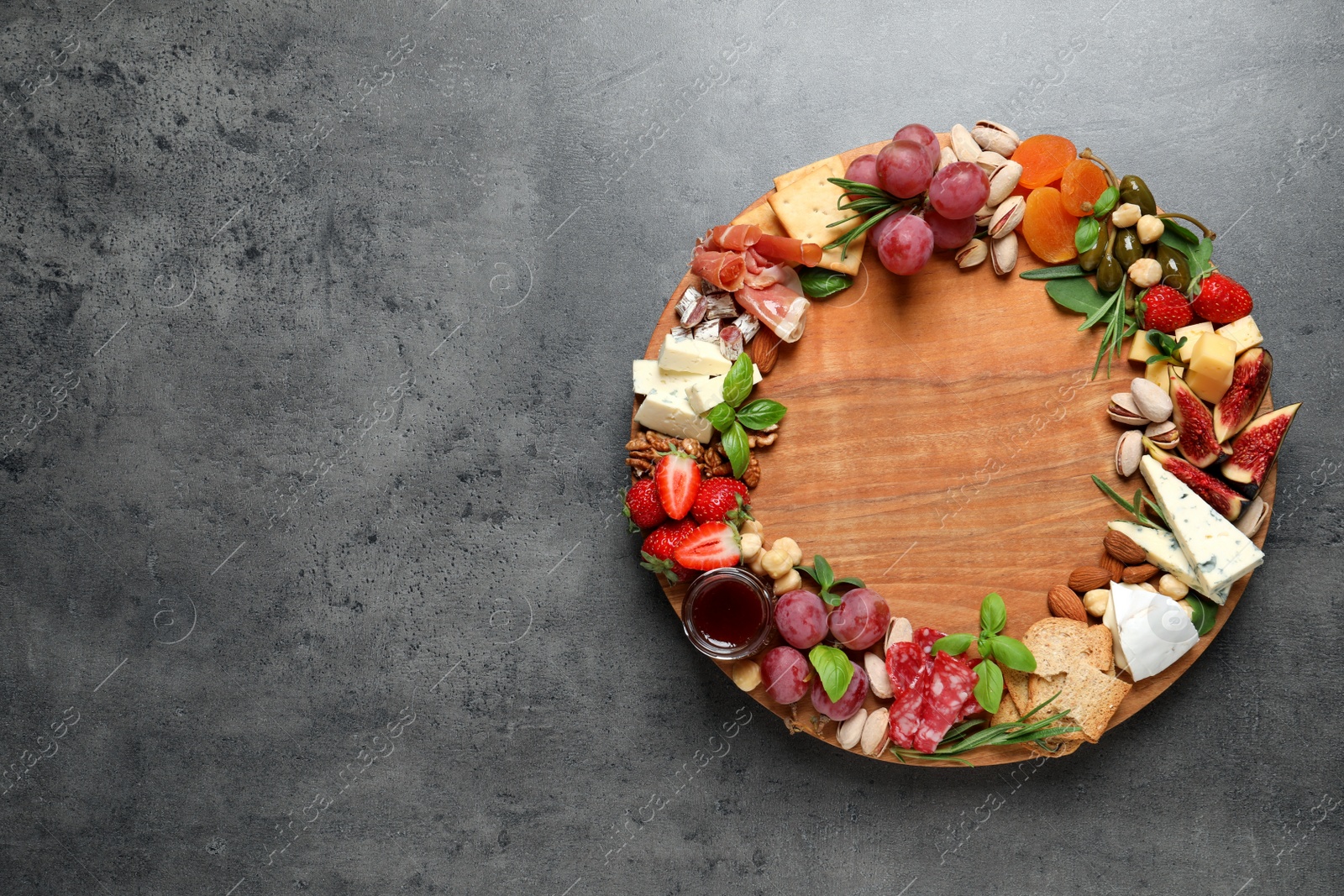 Photo of Different tasty appetizers on dark grey table, top view. Space for text