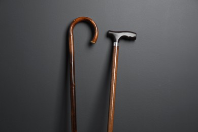 Different wooden walking canes on grey background