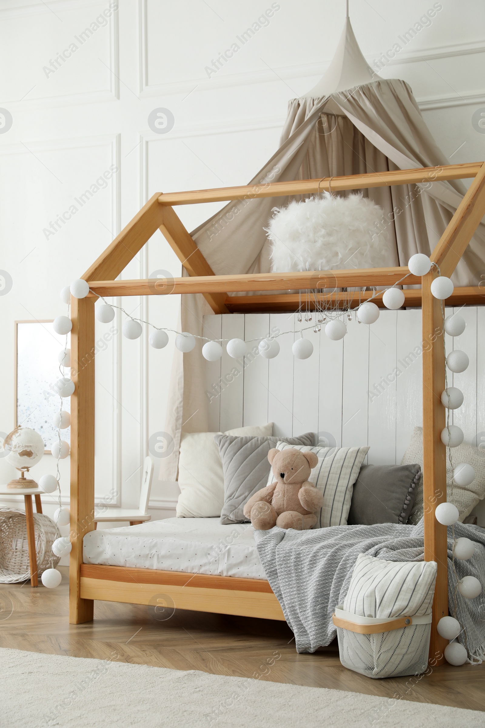 Photo of Stylish room for kid with house bed. Interior design