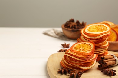 Photo of Dry orange slices., anise stars and cinnamon sticks on white table. Space for text