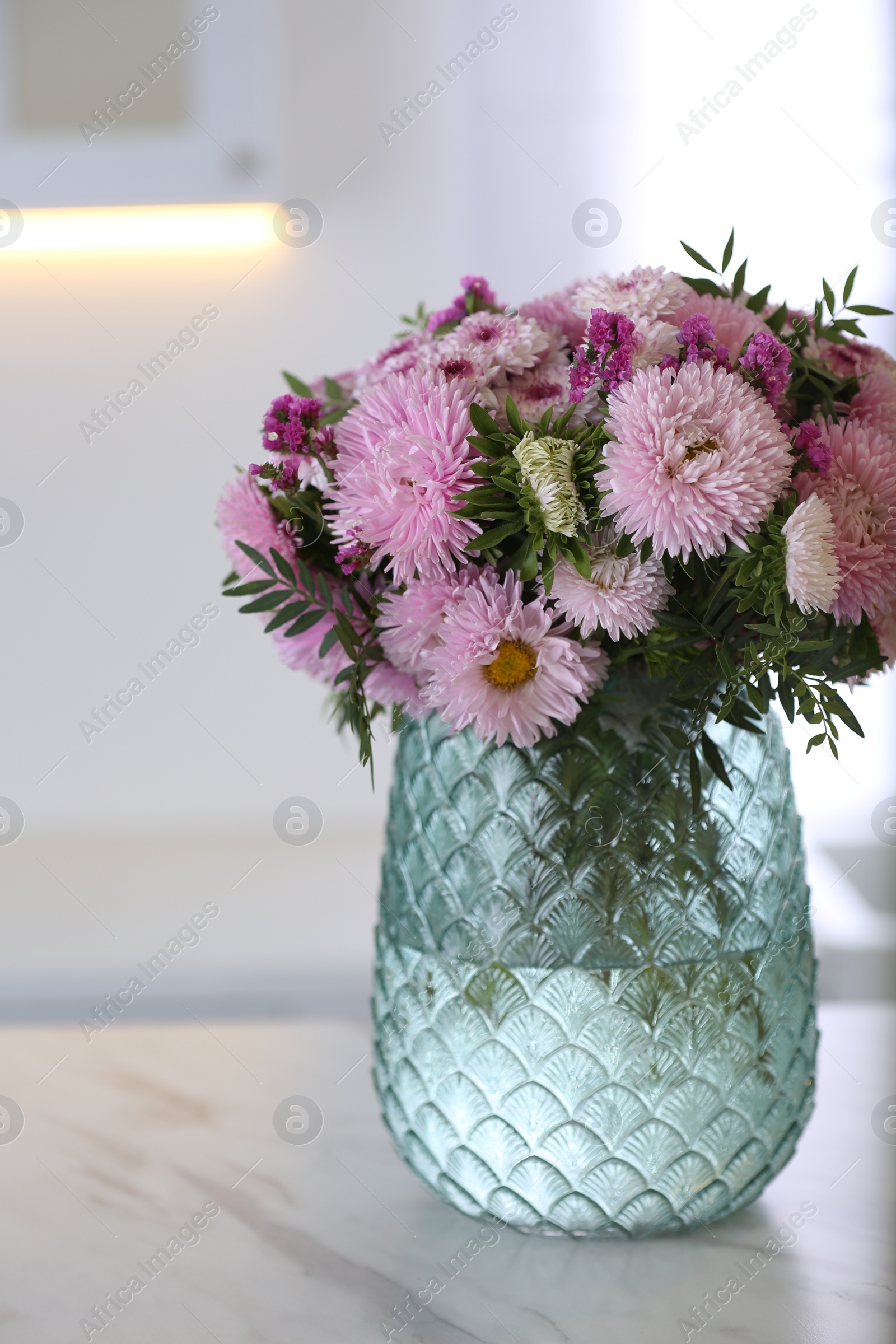 Photo of Vase with beautiful chrysanthemum flowers on table in kitchen. Interior design