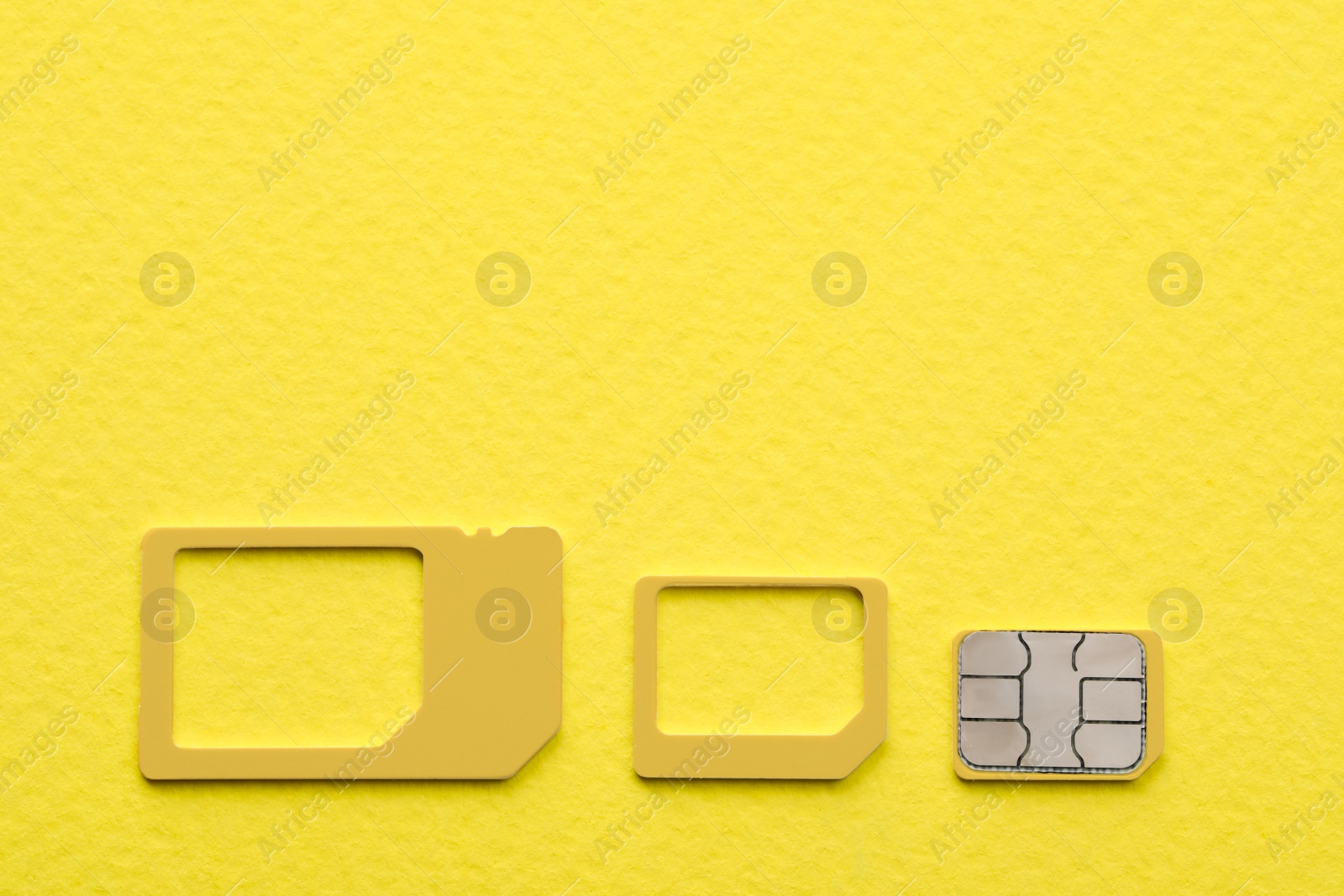 Photo of Multi SIM card on yellow background, flat lay. Space for text