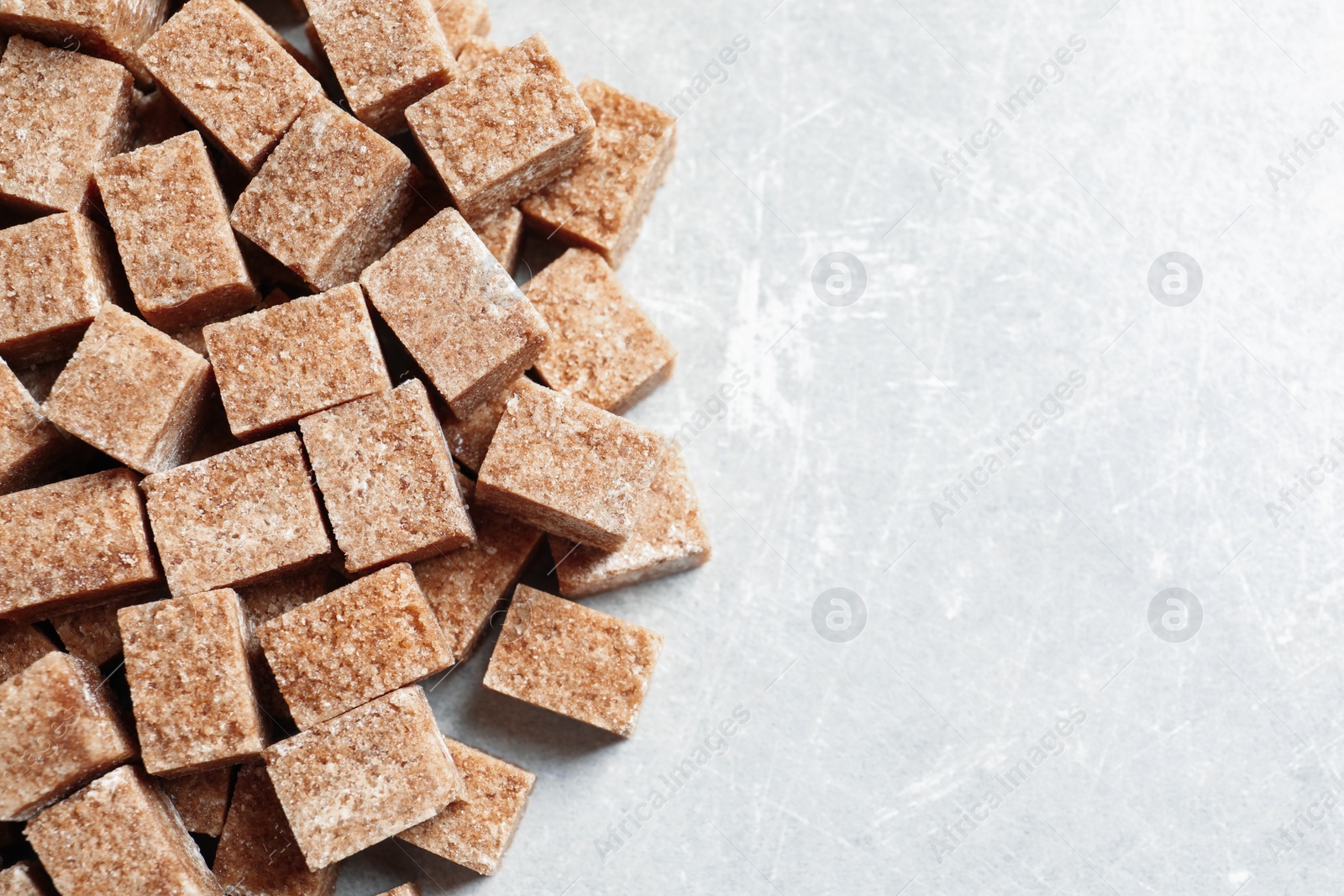 Photo of Cubes of brown sugar on gray background