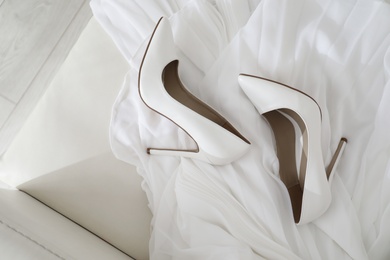 Photo of White wedding shoes on sofa, above view