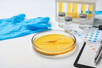 Photo of Glass dish with urine sample on table. Urology concept