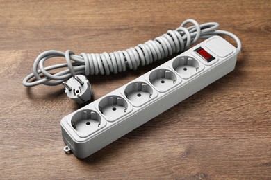 Power strip with extension cord on wooden floor. Electrician's equipment