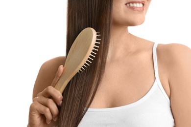 Woman with hair brush on white background, closeup