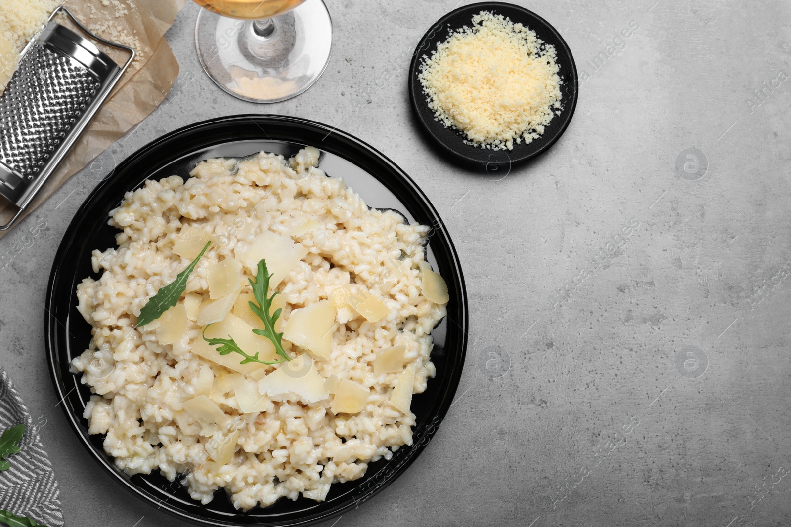 Photo of Delicious risotto with cheese on grey table, flat lay