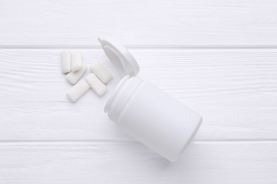 Jar with chewing gums on white wooden table, flat lay