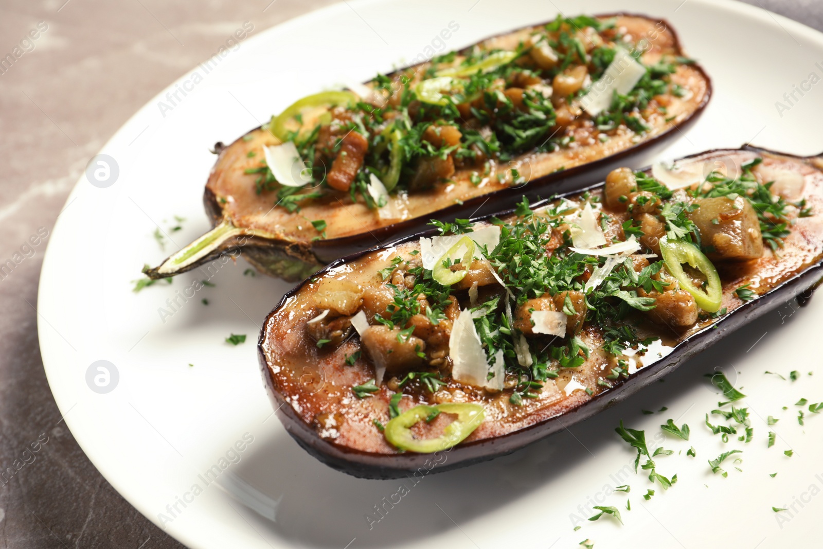 Photo of Plate with tasty stuffed eggplants on gray table