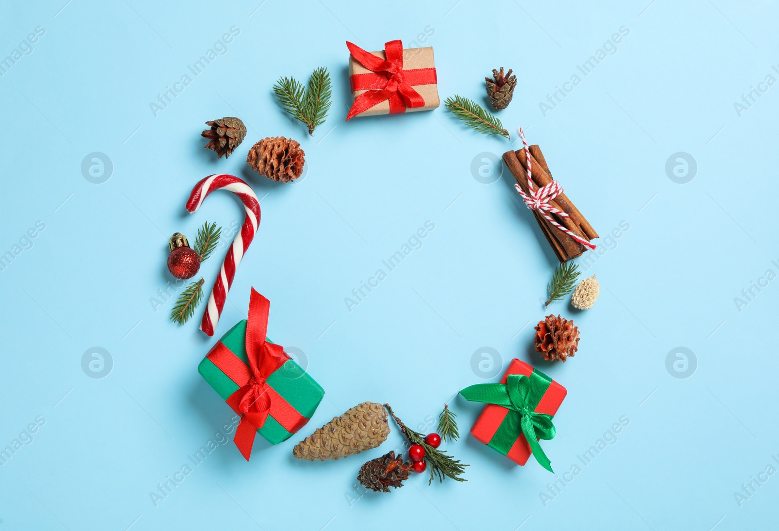 Photo of Frame of pinecones and festive decor on light blue background, flat lay. Space for text