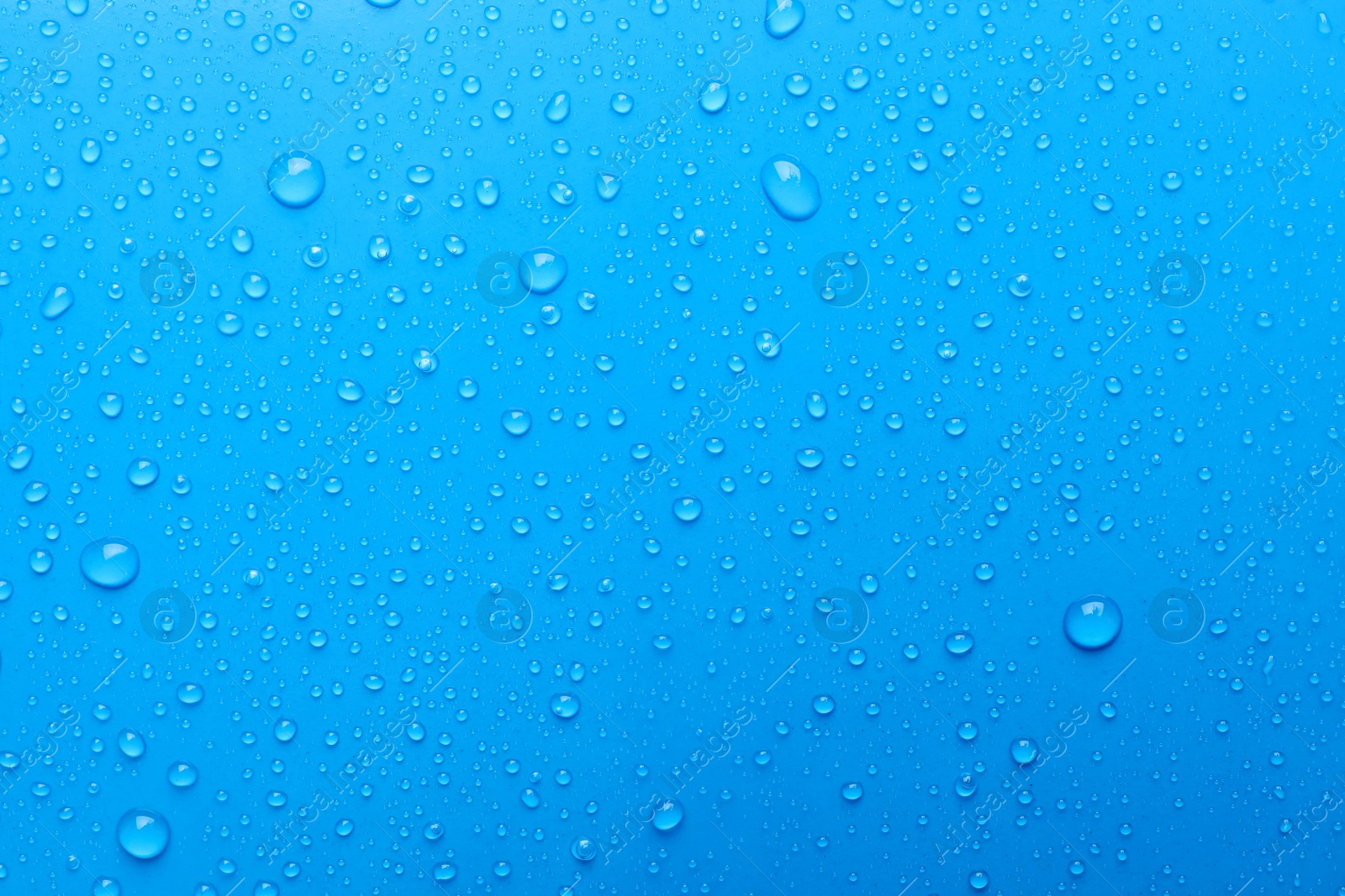 Photo of Water drops on light blue background, top view