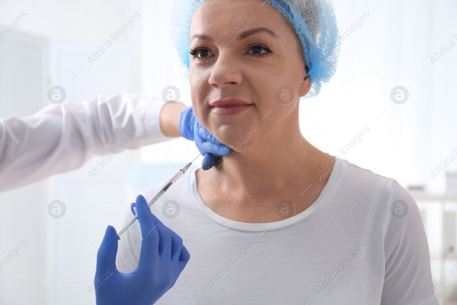 Photo of Mature woman with double chin receiving injection in clinic
