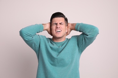 Photo of Portrait of stressed man on light background