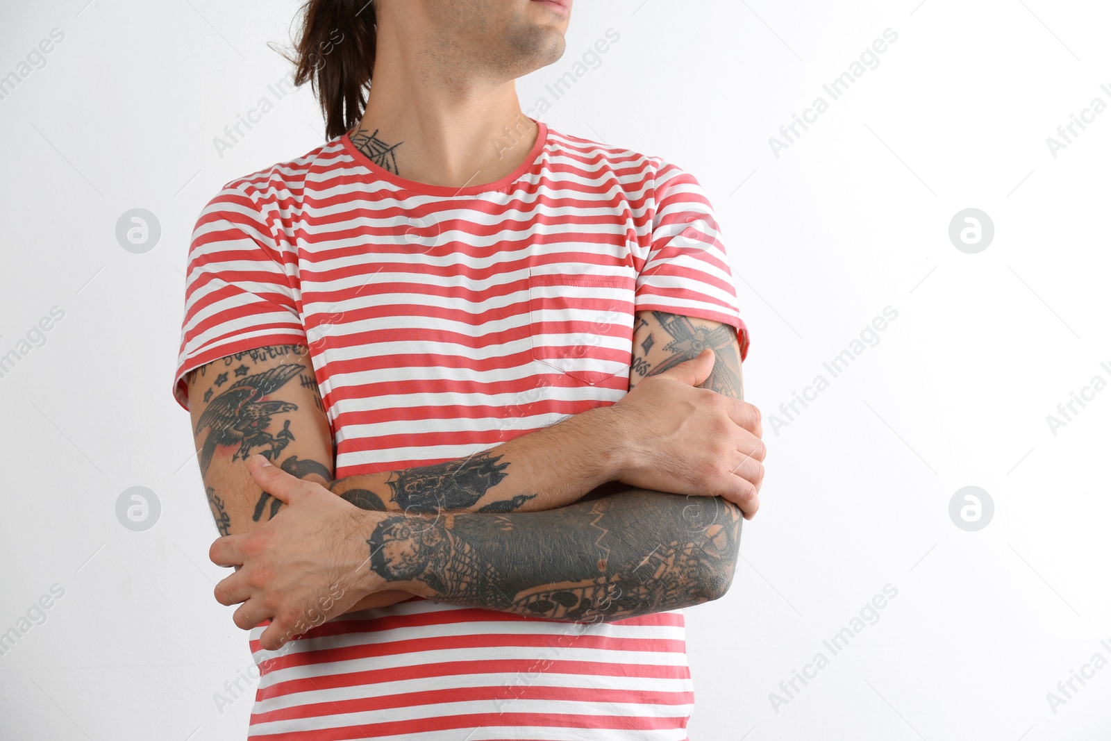 Photo of Young man with stylish tattoos on white background