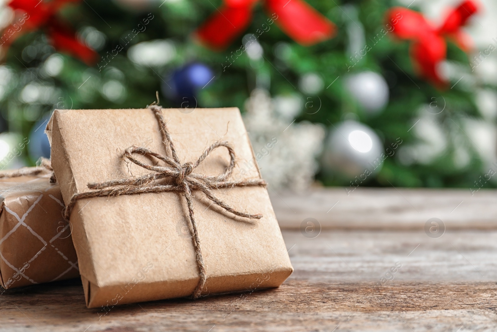 Photo of Beautiful gift boxes and blurred Christmas tree on background