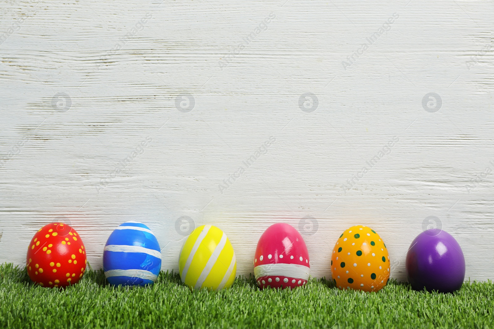 Photo of Decorated Easter eggs on green grass. Space for text