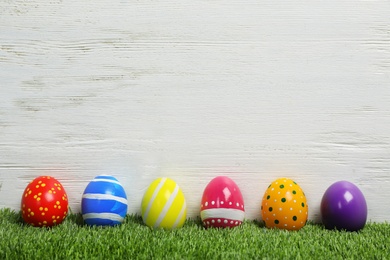 Decorated Easter eggs on green grass. Space for text