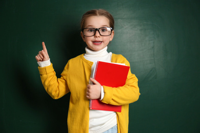 Cute little child wearing glasses near chalkboard. First time at school