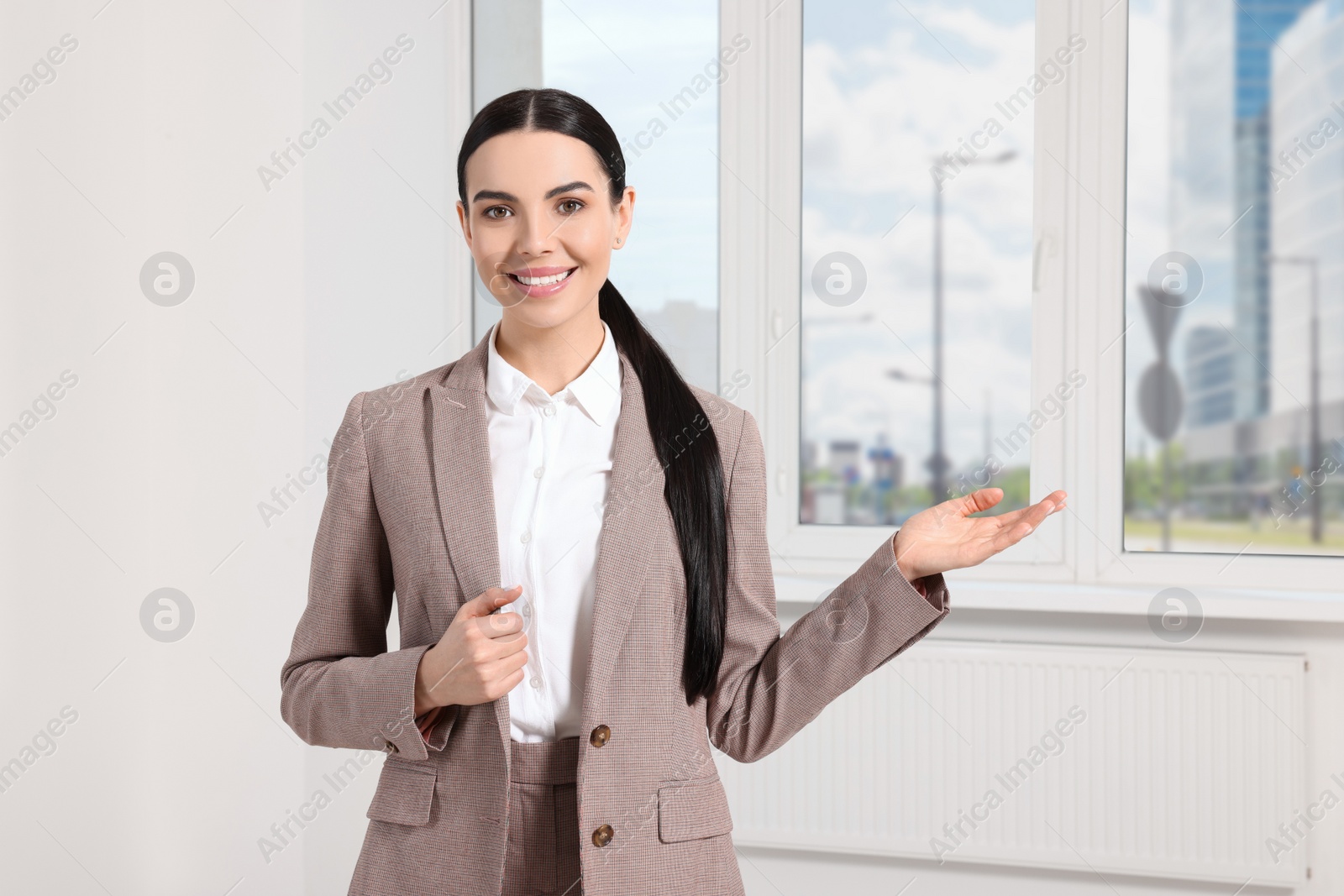 Photo of Beautiful real estate agent in nice suit indoors, space for text