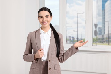 Photo of Beautiful real estate agent in nice suit indoors, space for text