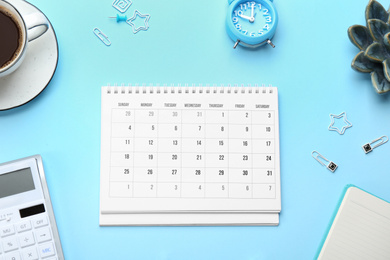 Flat lay composition with calendar on light blue background