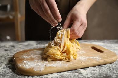 Photo of Woman preparing pasta at table, closeup view