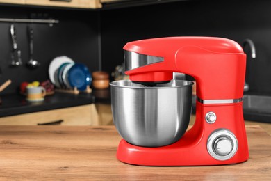 Photo of Modern red stand mixer on wooden table in kitchen