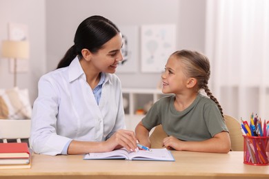 Dyslexia treatment. Therapist working with girl at table in room