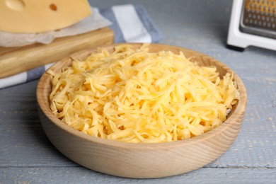 Photo of Tasty grated cheese on light grey wooden table