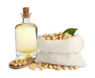 Glass bottle of oil and soybeans on white background