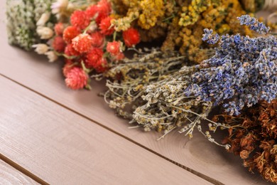 Photo of Different medicinal herbs on wooden table, closeup. Space for text