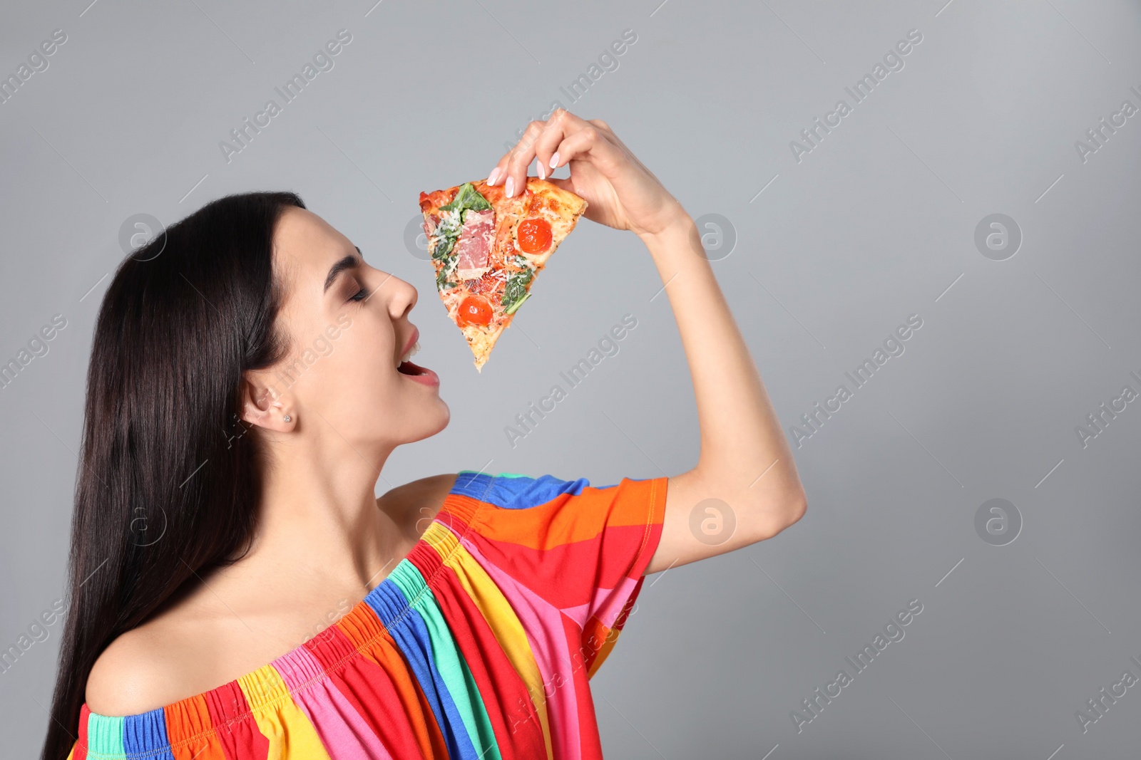 Photo of Beautiful woman with pizza on grey background, space for text