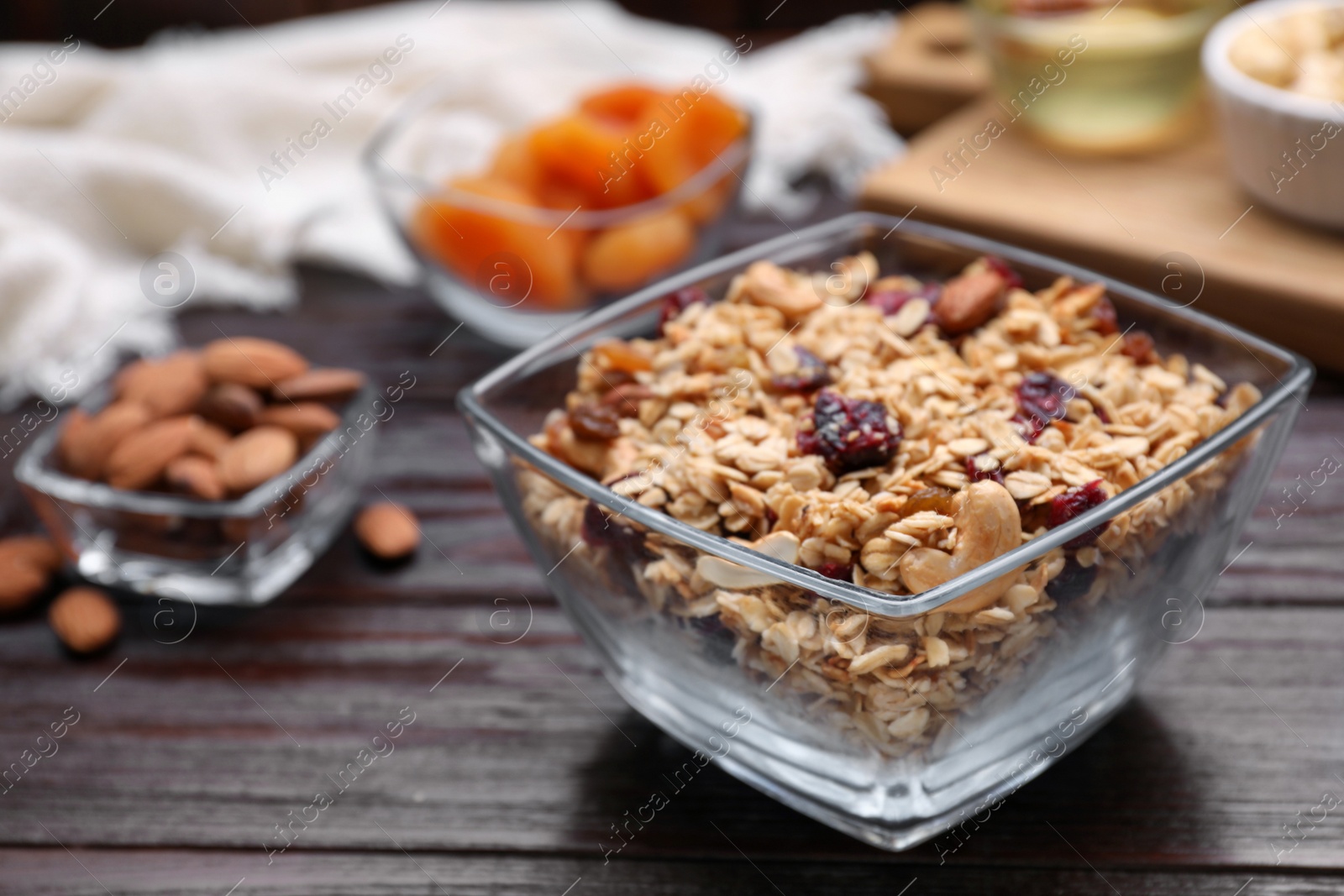 Photo of Tasty granola served with nuts and dry fruits on wooden table