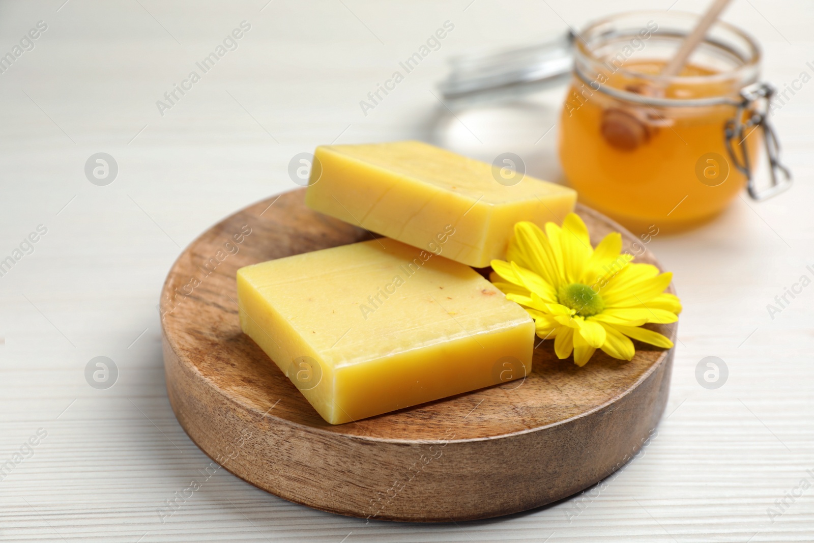 Photo of Natural beeswax and flower on white wooden table