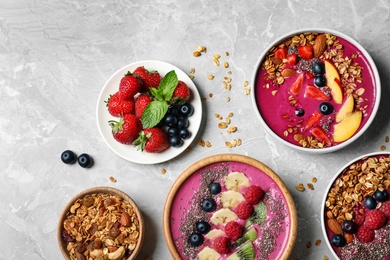 Acai smoothie bowls with granola and berries on marble table, flat lay