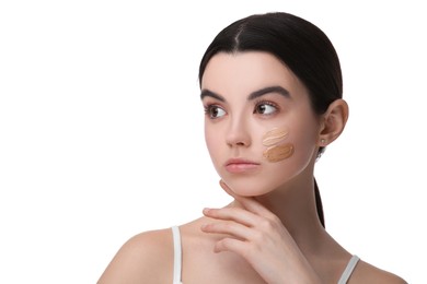 Photo of Teenage girl with swatches of foundation on face against white background