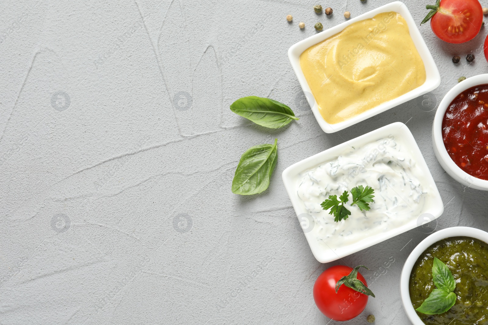 Photo of Flat lay composition with different sauces and space for text on gray background