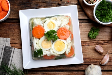 Delicious fish aspic served on wooden table, flat lay