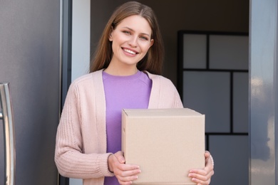 Portrait of smiling woman with parcel at door, mockup for design. Delivery service