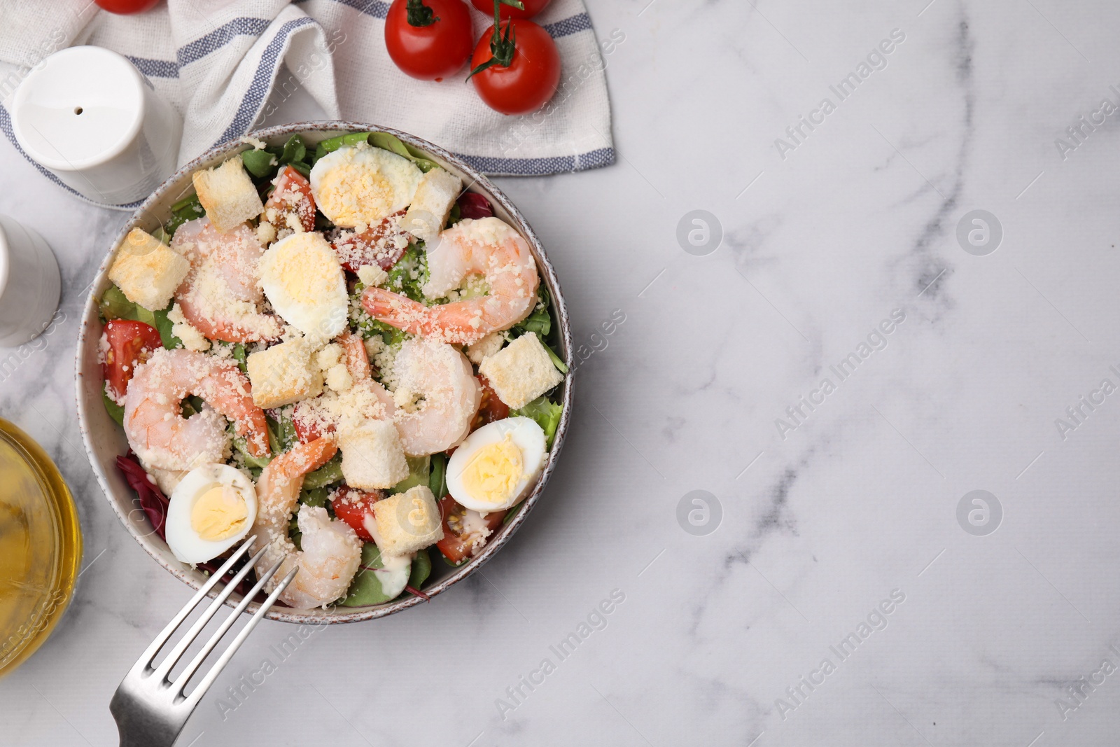 Photo of Delicious Caesar salad with shrimps served on white marble table, flat lay. Space for text